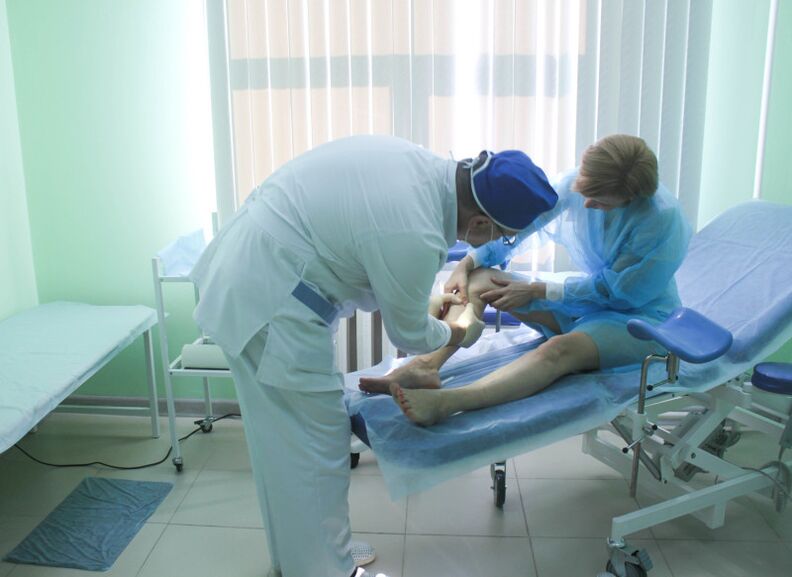 A surgeon examines a patient's veins before performing an operation.